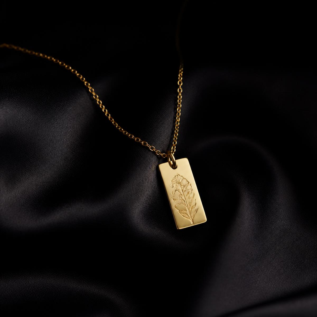 Gold chain with rectangular tag pendant on black silk
